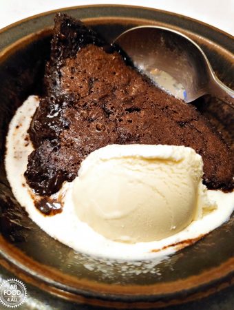 Chocolate Puddle Pudding with vanilla ice cream in a bowl.