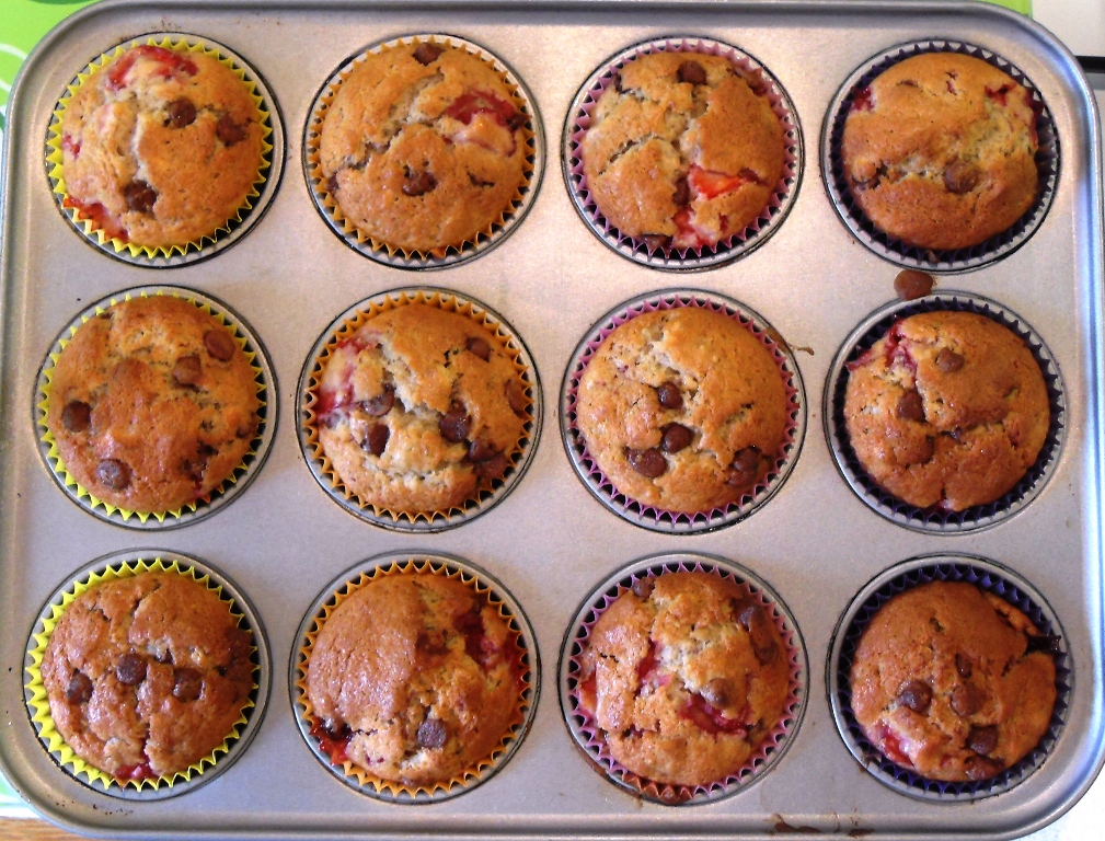 Baked Strawberry Banana Chocolate Chip Muffins in a muffin tray.