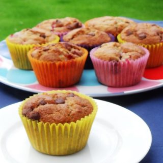 Strawberry Banana Chocolate Chip Muffins on a serving platter and a plate.