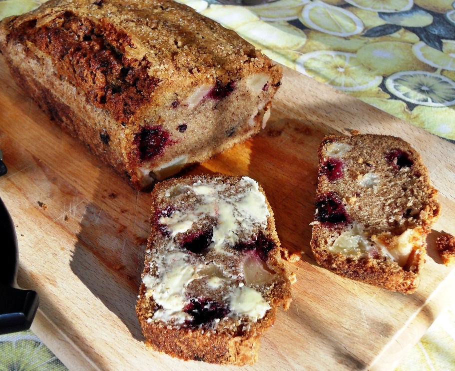 Blackberry and Apple Loaf, sliced and buttered on a board.
