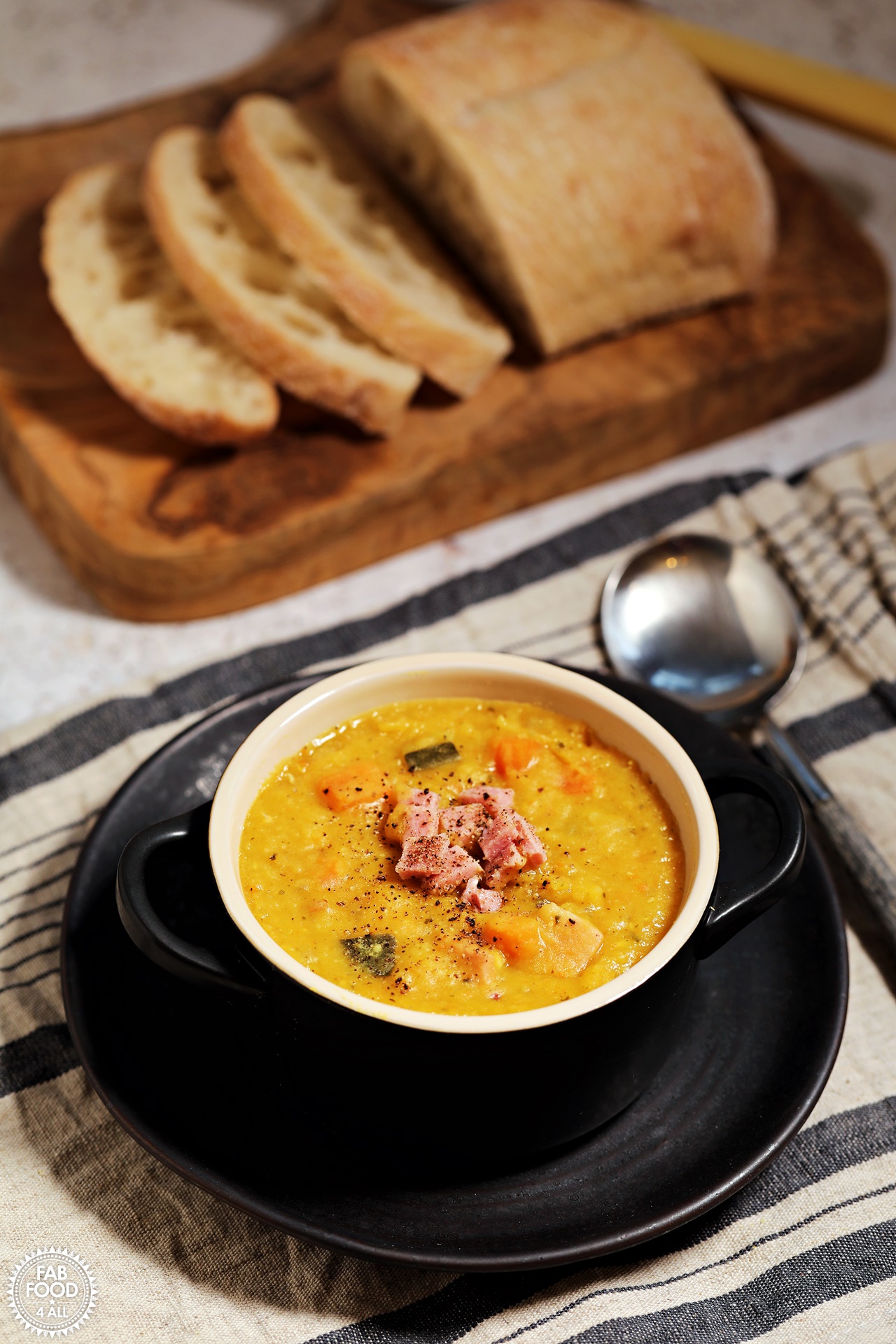 Lentil & Ham Soup with bread on a board.