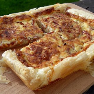 Quiche Lorraine with Slow Cooked Pulled Gammon on a wooden board.