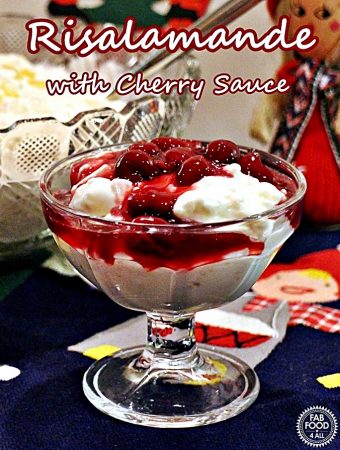 A portion of Risalamande (Danish Rice Pudding) and cherry sauce in a glass sundae dish.