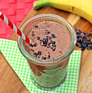 Banana & Cacao Milkshake in a glass with stripey red & white straw.