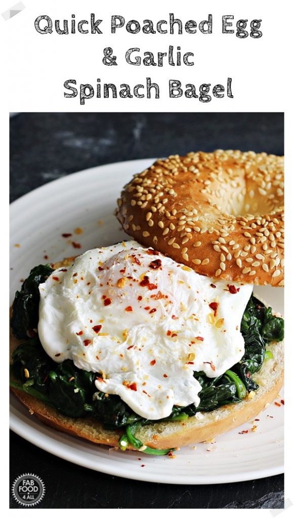 Poached Egg & Garlic Spinach Bagel served on a white plate on a slate.