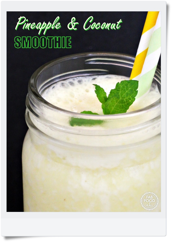 Pineapple & Coconut Smoothie in glass mug with sprig of mint & 2 straws. Pinterest image.