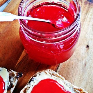 Jar of Easy Seedless Raspberry Jam with currant bun.