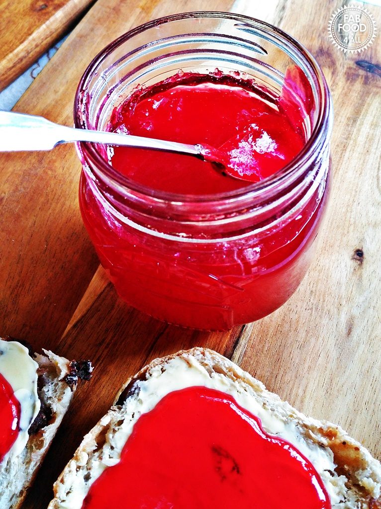 Jar of Easy Seedless Raspberry Jam with currant bun.