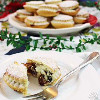 A serving plate full of Cheat's Mince Pies showing one cut in half on a plate in the foreground.