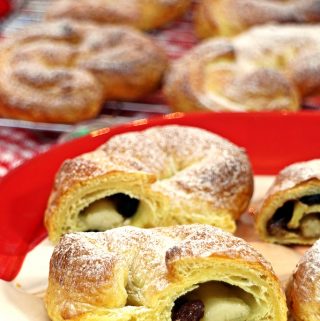 Cheat's Stollen Croissants 2 Ways cut up on a plate with more on cooling rack in background.