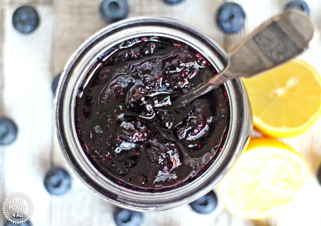 Blueberry Jam in a jar with spoon, aerial view.