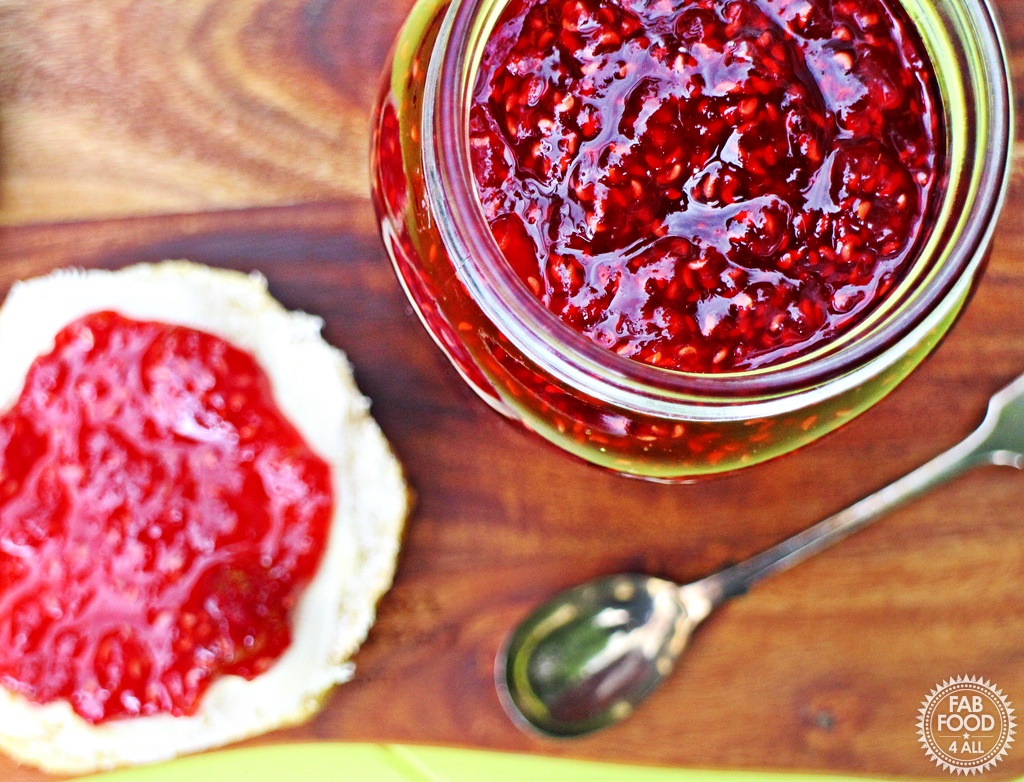 Quick & Easy Raspberry Jam with scone & teaspoon on wooden board.