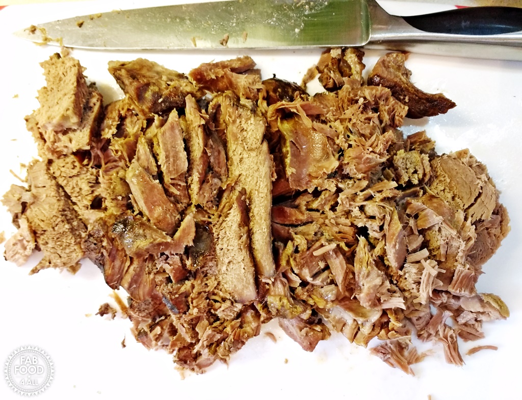 2 Ingredient Slow Cooker Roast Lamb chopped up on a board.