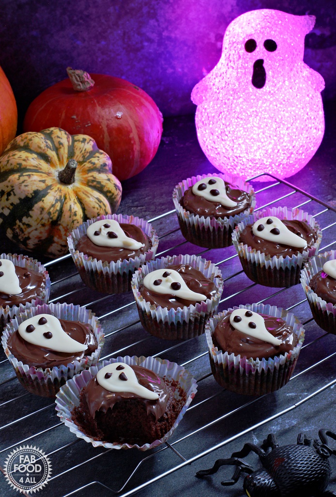 Easy Halloween Ghost Cupcakes - delicious chocolate & coffee flavoured sponge topped with chocolate spread & a handmade white chocolate ghost. Ghost and pumpkin background.
