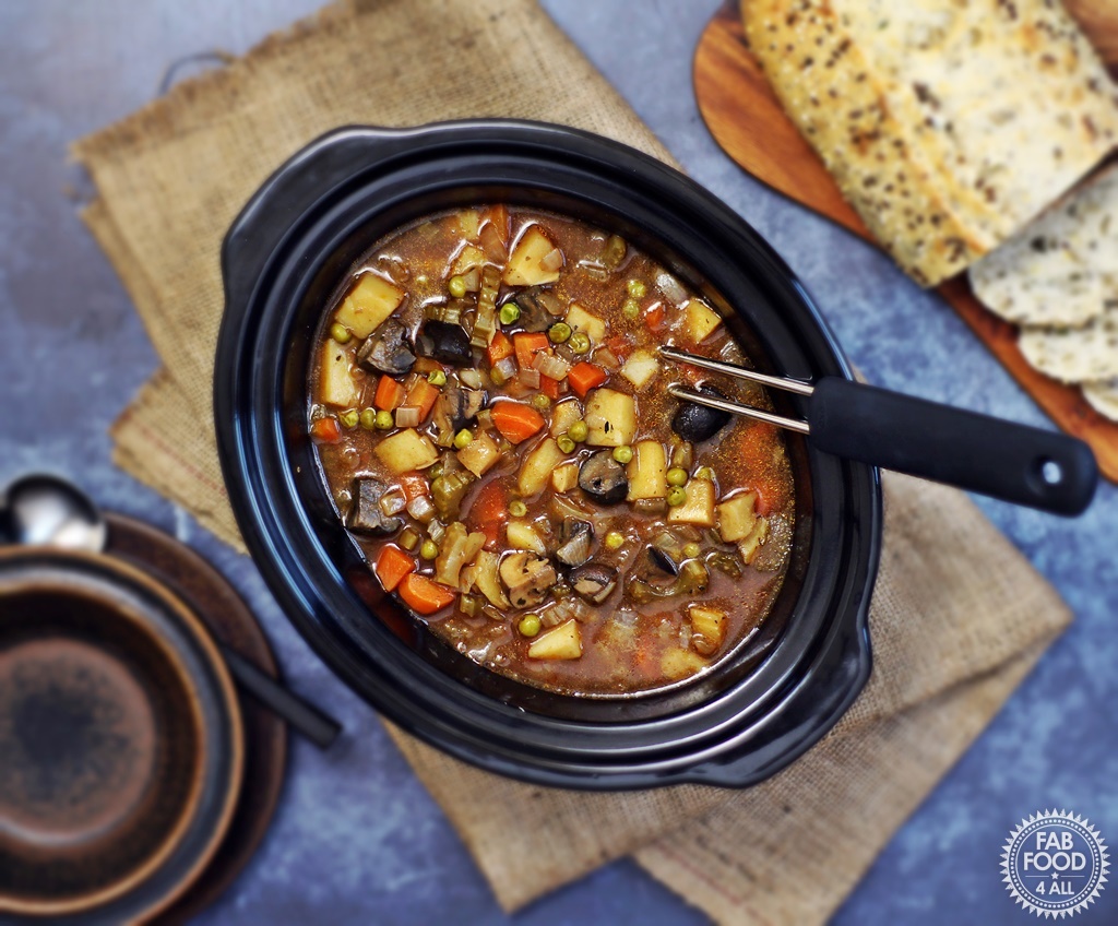 Easy Slow Cooker Vegan Stew - a hearty, tangy stew with root vegetables, Chestnut mushrooms & peas. Serve with crusty bread to mop up the cooking juices! #slowcooker