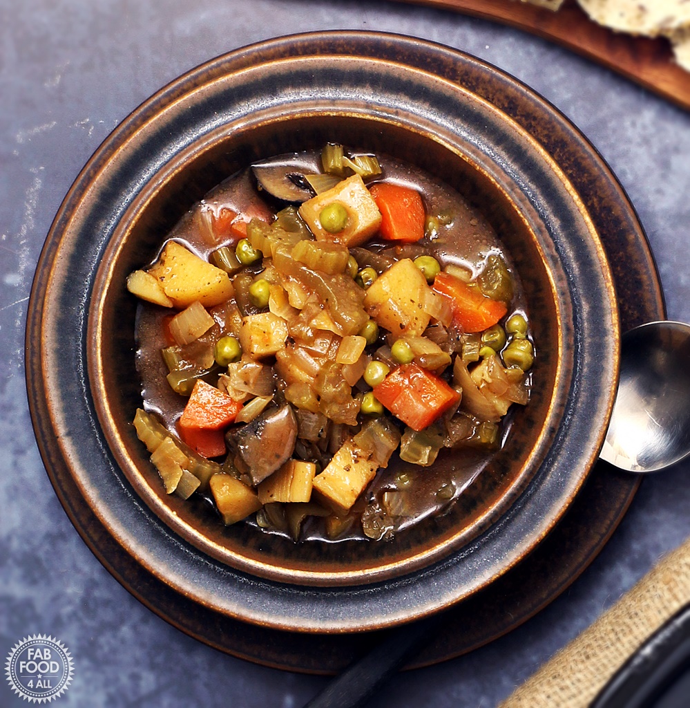 Easy Slow Cooker Vegan Stew - a hearty, tangy stew with root vegetables, Chestnut mushrooms & peas. Serve with crusty bread to mop up the cooking juices! #slowcooker #crockpot