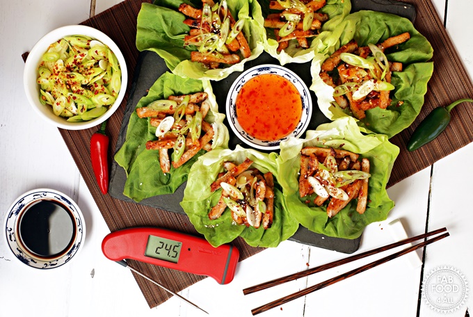 Korean BBQ Style Spicy Pork Lettuce Wraps - stripes of marinated pork on lettuce leaves, garnished with spring onion & served with sweet chilli sauce and soy sauce. Thermapen Professional digital thermometer also displayed.