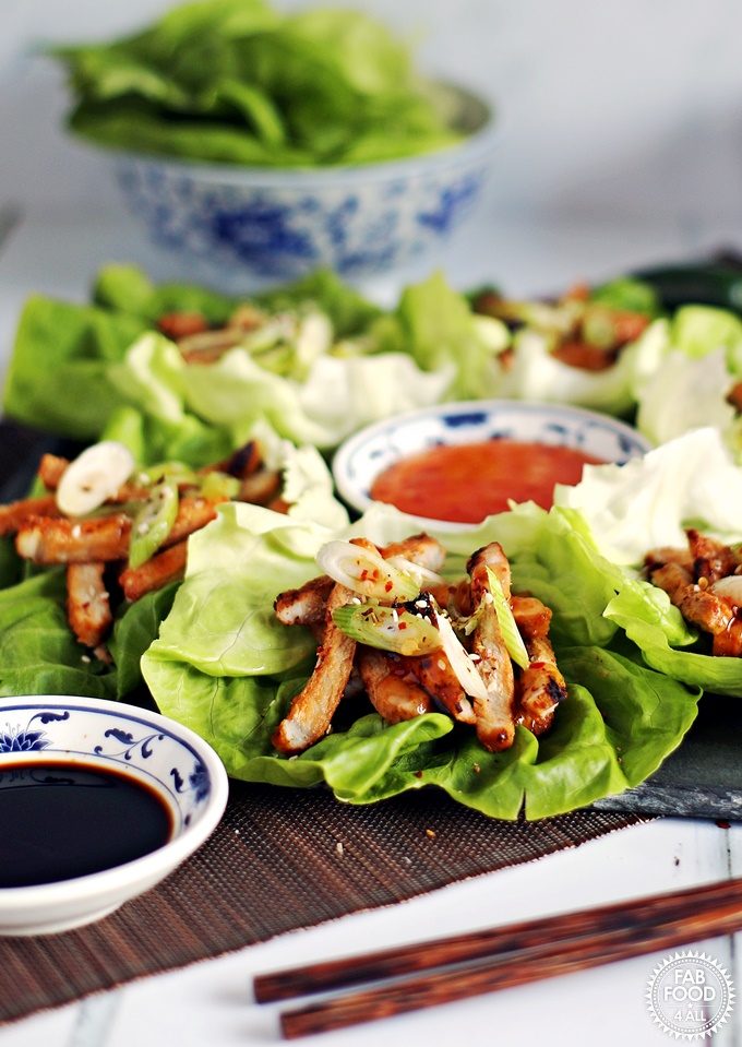 Korean BBQ Style Spicy Pork Lettuce Wraps - stripes of marinated pork on lettuce leaves, garnished with spring onion & served with sweet chilli sauce and soy sauce.