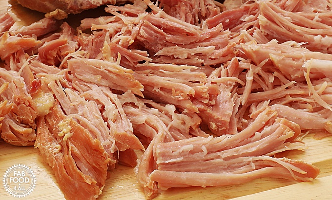 2 Ingredient Pulled Slow Cooker Gammon (Shredded Ham) on a board.