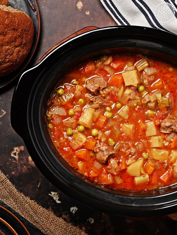 Slow Cooker Beef Stew in slow cooker dish with rolls.