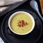 Easy Broccoli Cheddar Soup in a bowl with spoon & slices of toast on a slate.