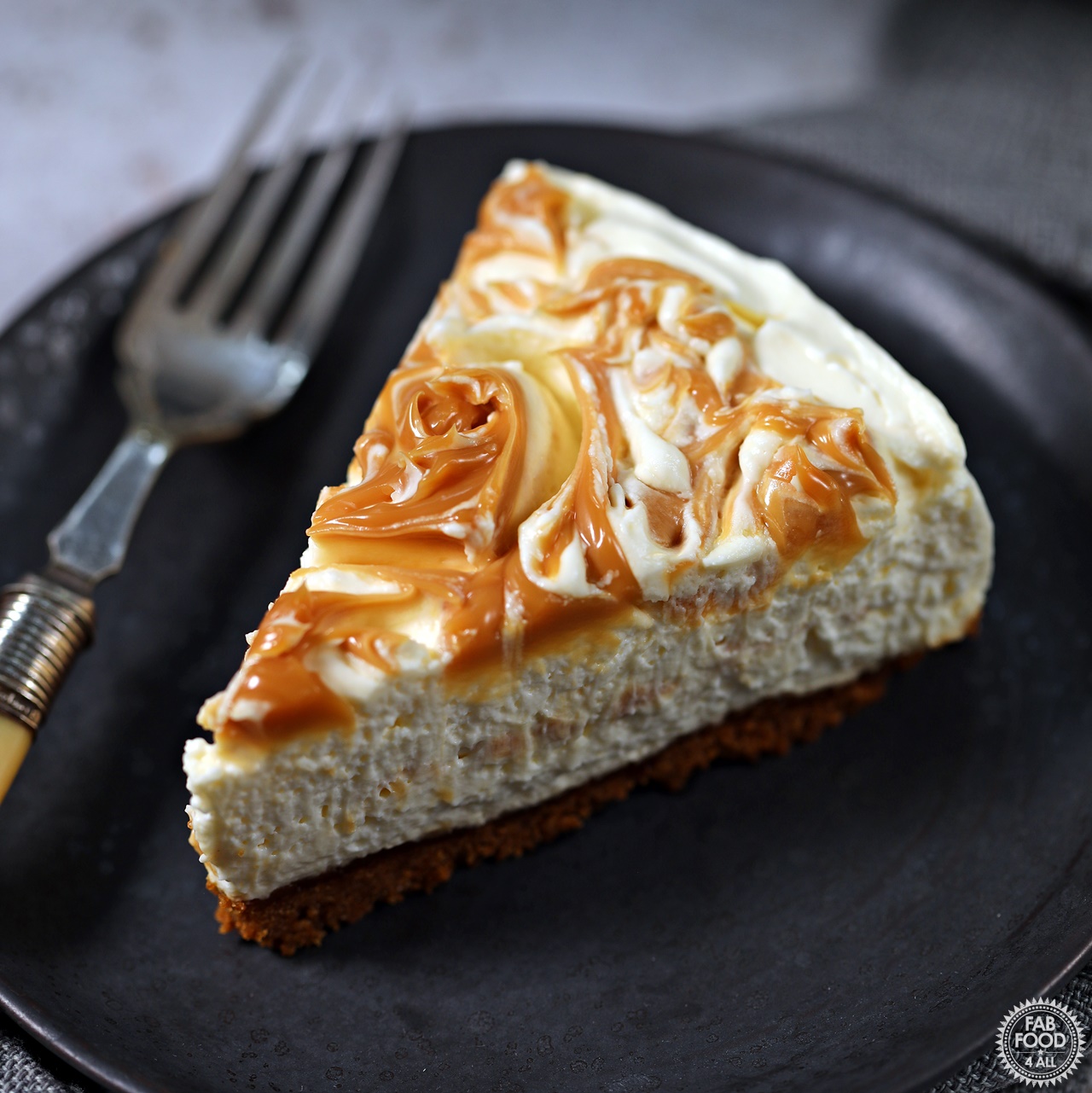 Slice of Easy No Bake Salted Caramel Cheesecake on a plate with fork.