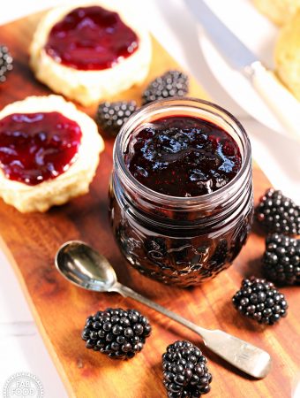 Easy Seedless Blackberry Jam with scone. and blackberries on a board.