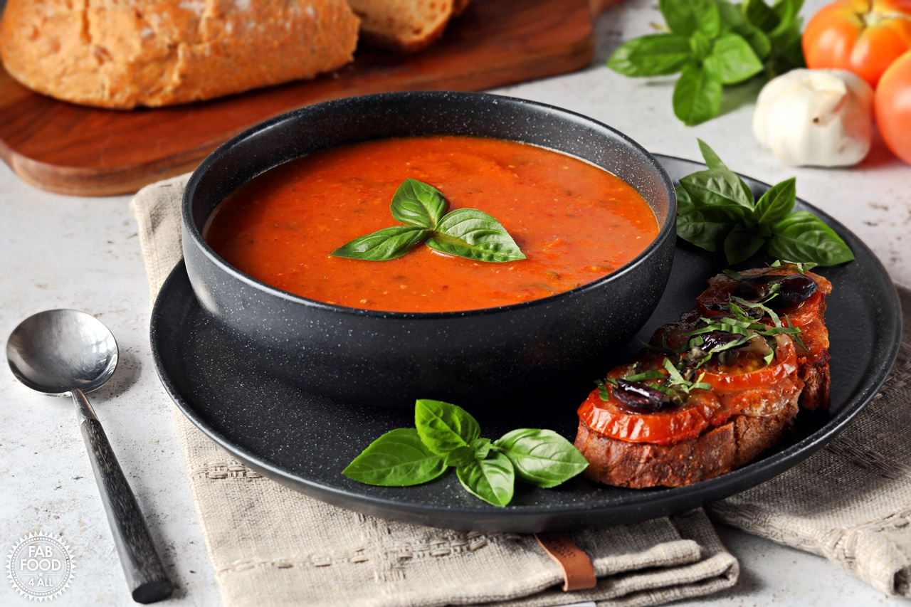 Roasted Tomato & Garlic Soup with Basil in a bowl with pizzetta toast.