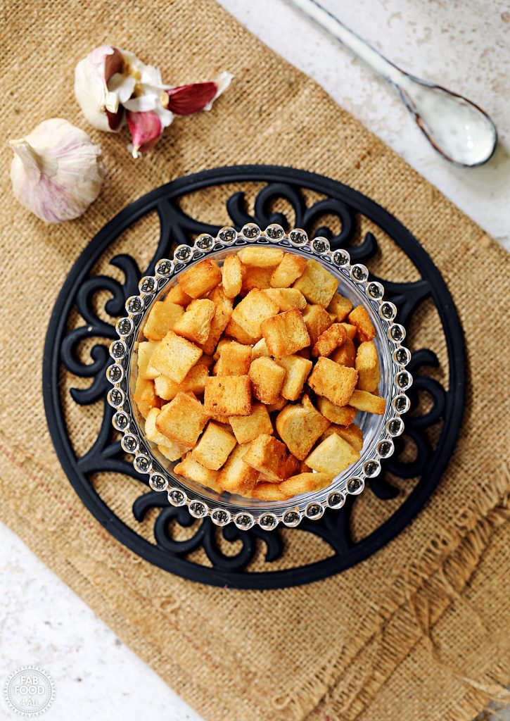 Easy Garlic Croutons in a glass bowl on hessian cloth.
