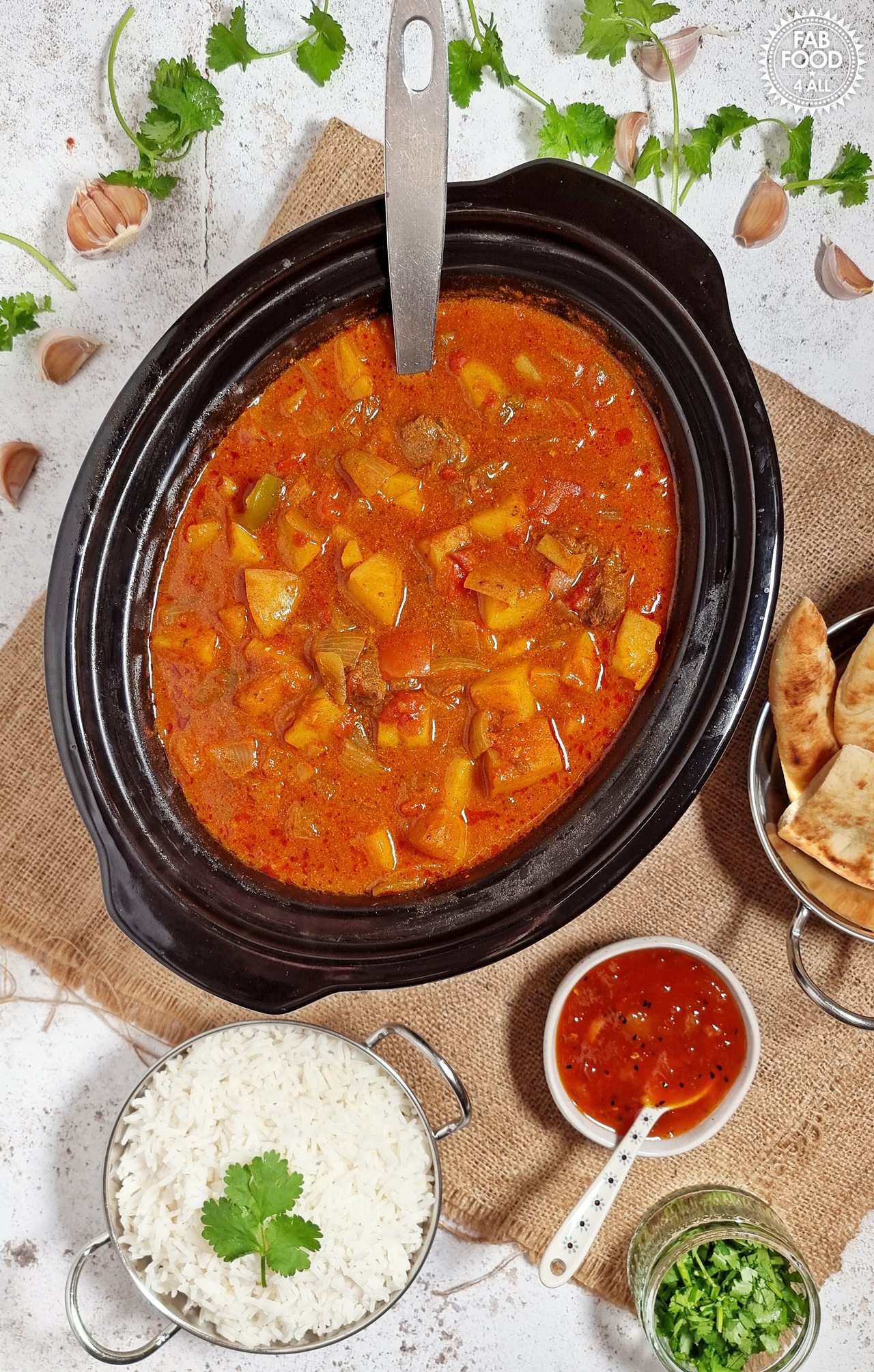 Easy Slow Cooker Beef Curry in slow cooker with naan bread, mango chutney and rice.