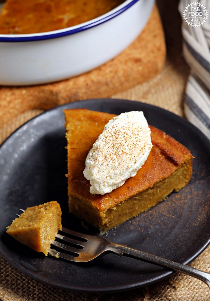 Easy Pumpkin Pie Pudding on a plate topped with whipped cream & dusting of cinnamon..