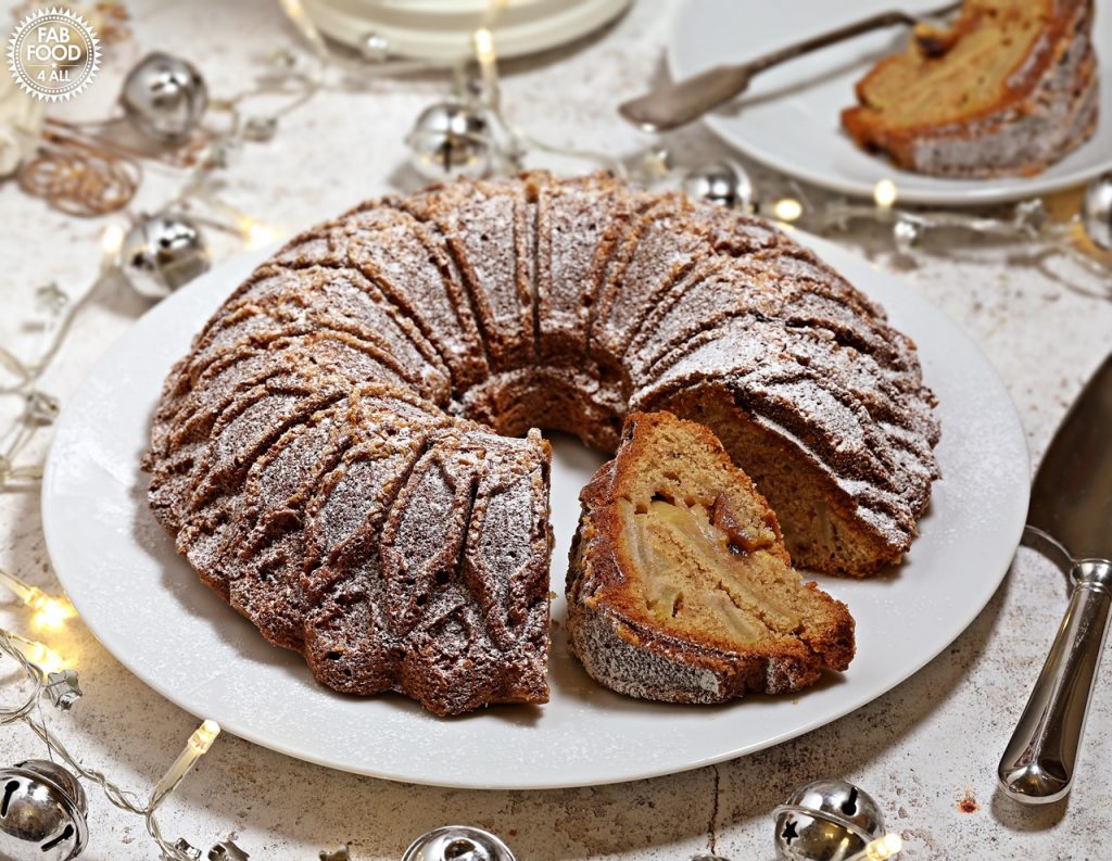 Christmas Bundt Cake on a serving plate with cut slice showing apple and mincemeat filling..