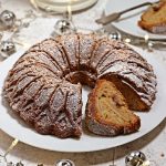 Christmas Bundt Cake on a serving plate with cut slice showing apple and mincemeat filling..