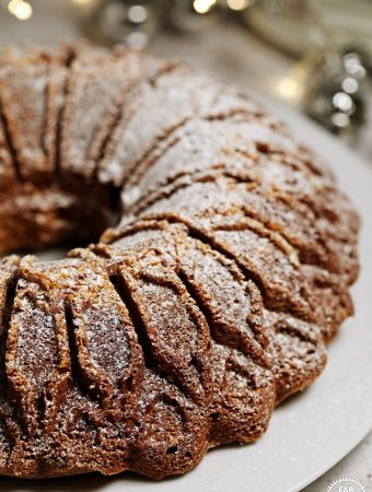 Christmas Bundt Cake with Christmas lights twinkling in background.