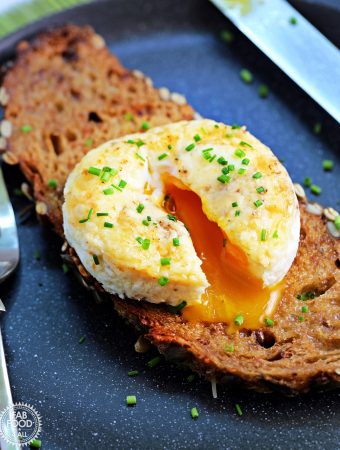 Close up of Air Fryer Baked Egg with Cheese on toast, garnished with chives.