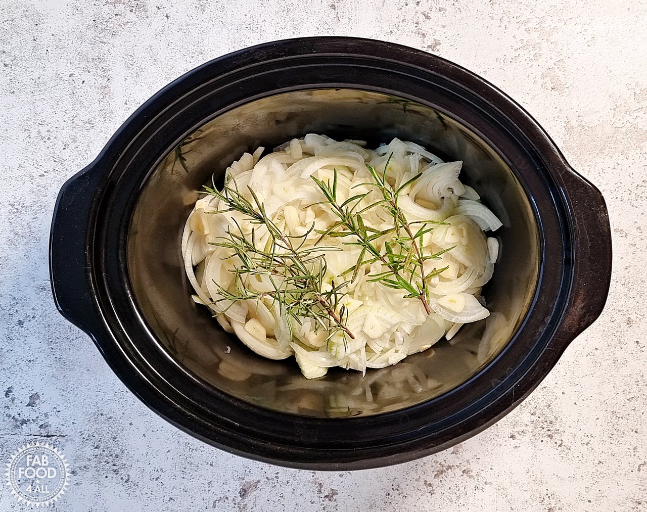 Onions, garlic & rosemary in slow cooker.