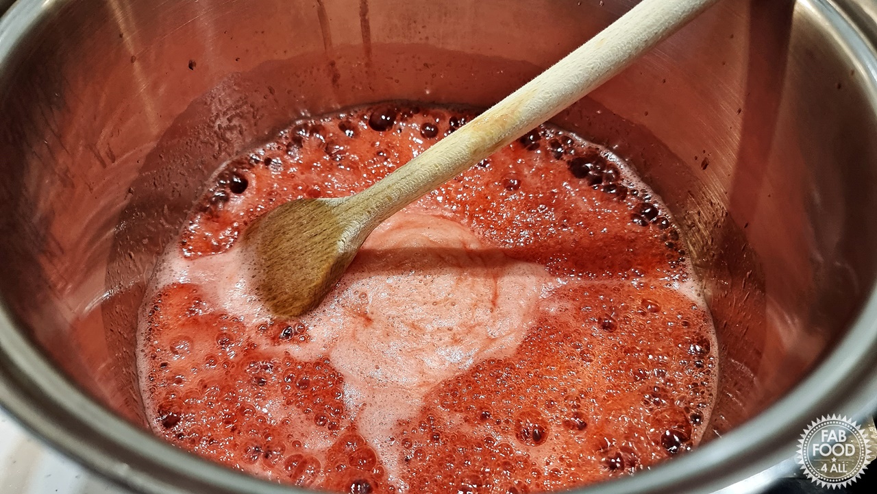 Jam on a rolling boil in pan with large wooden spoon.