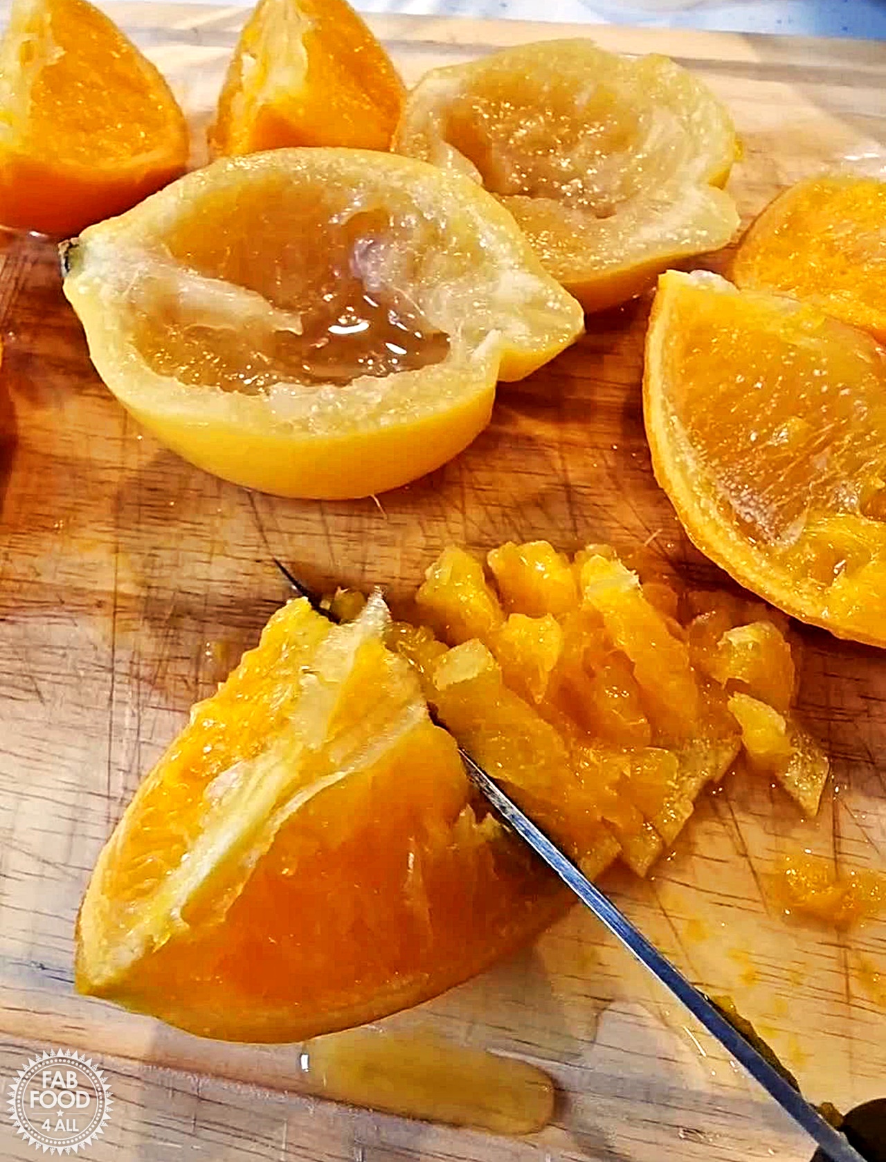 Slicing up orange and lemon rind quarters after boiling whole fruits.