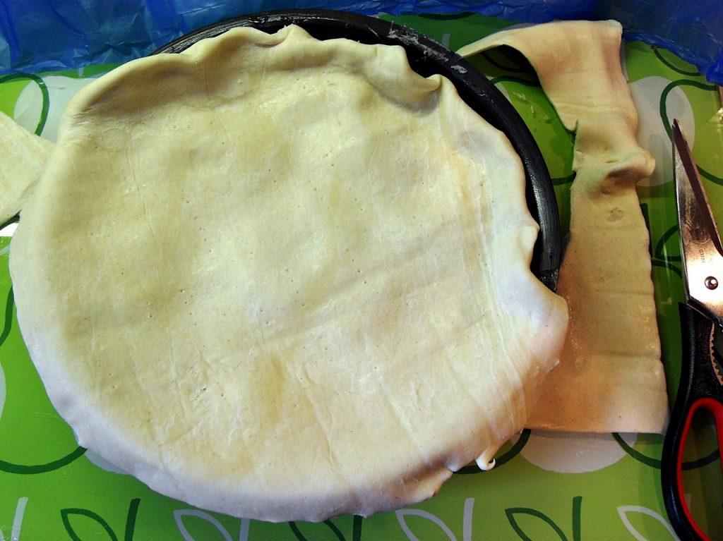 Folding puff pastry in around rim of tarte tatin dish.