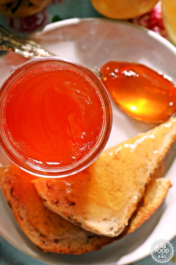 Overhead shot of Rosehip & Apple Jelly on plate with toast and teaspoon of jelly.