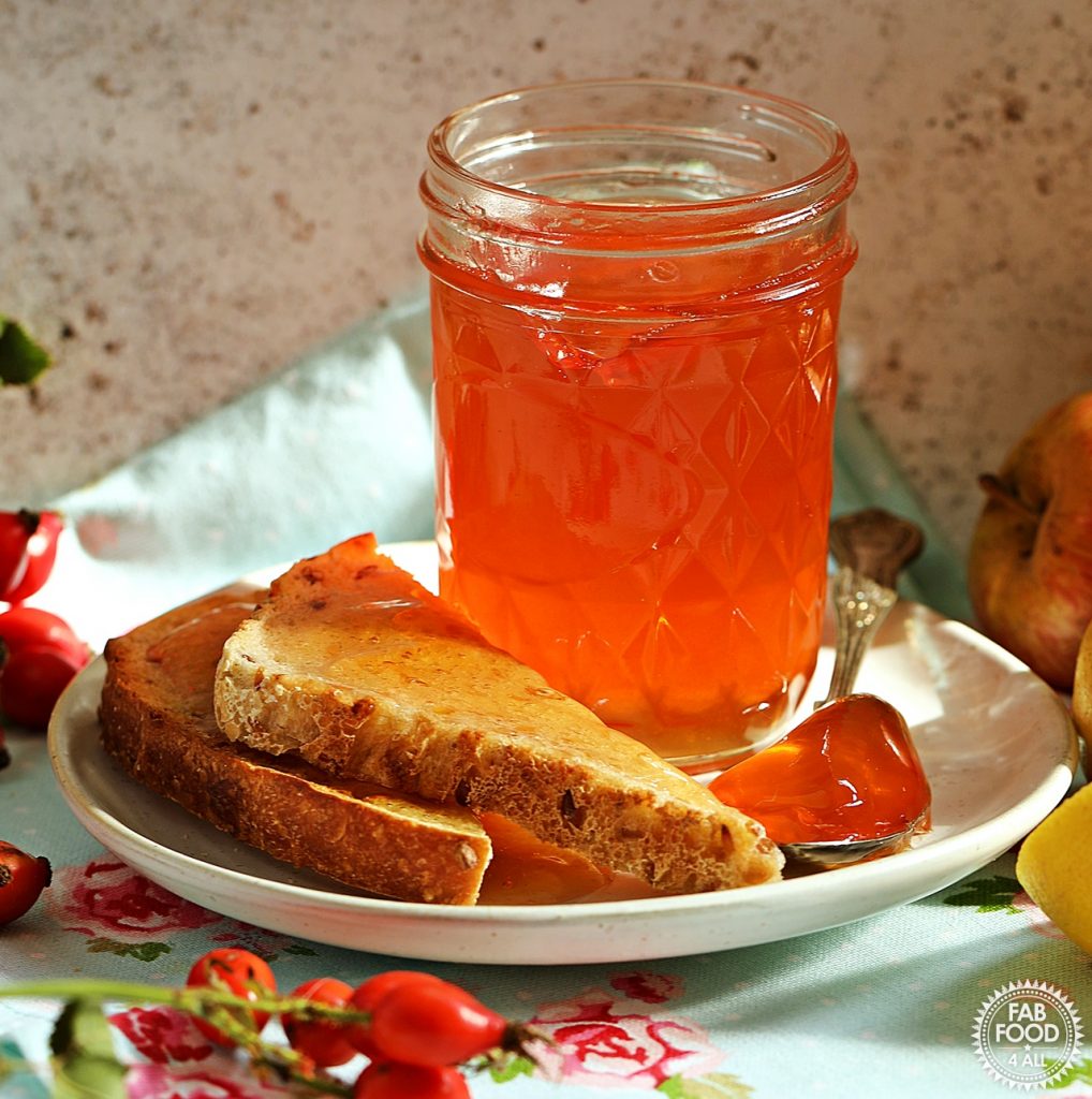 Jar of Rosehip & Apple Jelly on a plate with toast.
