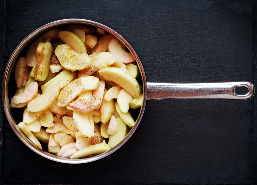 Sliced apples, vanilla sugar, granulated sugar and 1 tbsp of water in a pan.
