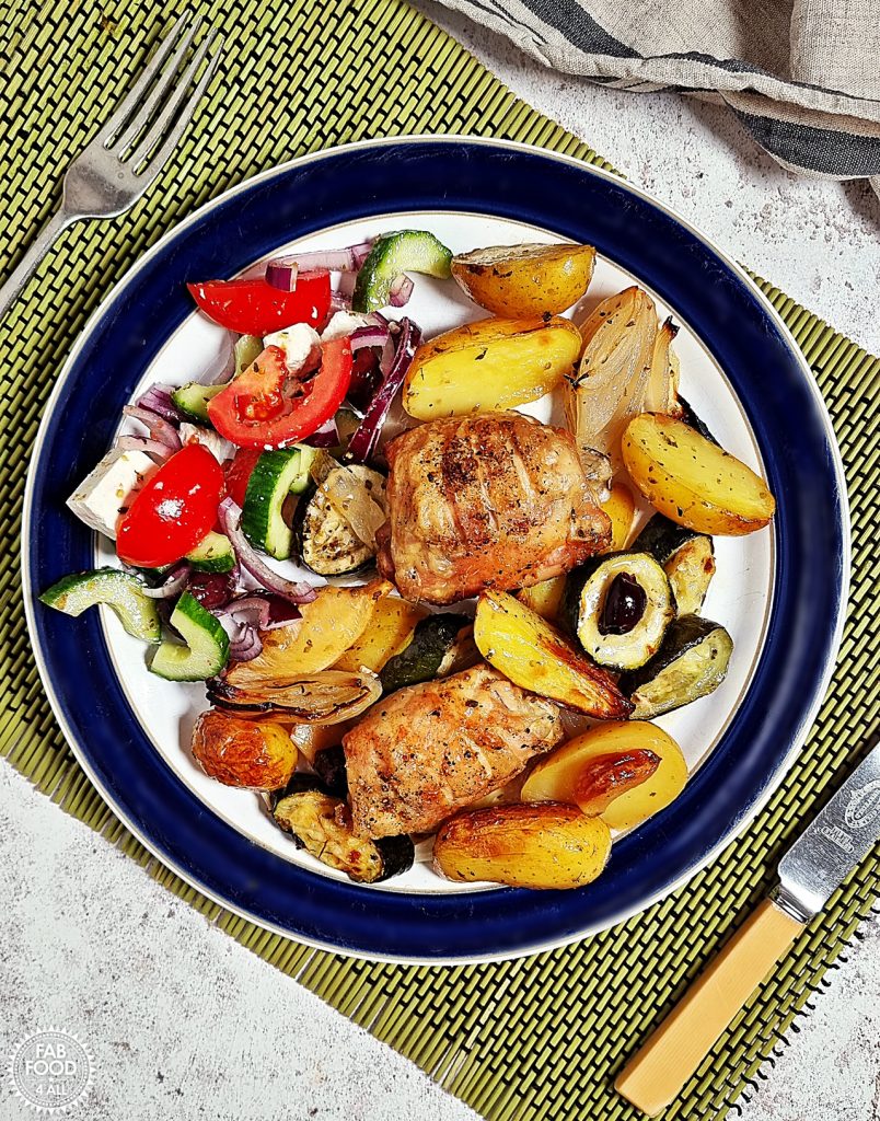 Easy Greek Chicken and Potatoes served on a plate with Greek Salad