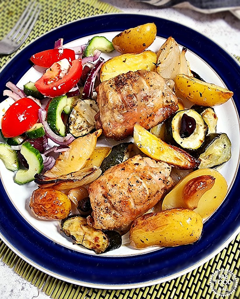 Easy Greek Chicken & Potatoes served on a plate with Greek Salad.