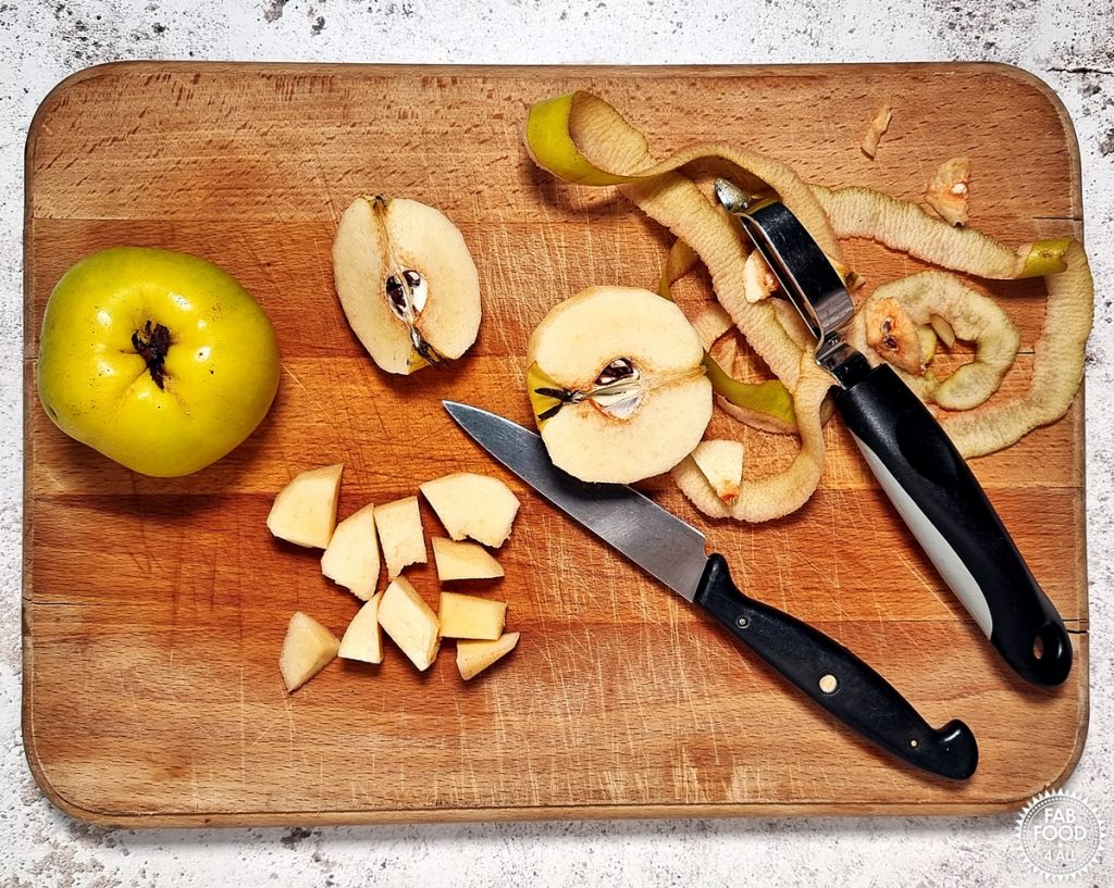 Quince being peeled and chopped on a board.