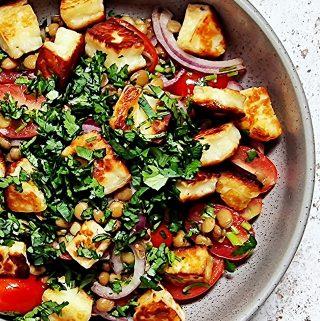 Overhead shot of Warm Lentil, Cherry Tomato and Halloumi Salad in a grey bowl.
