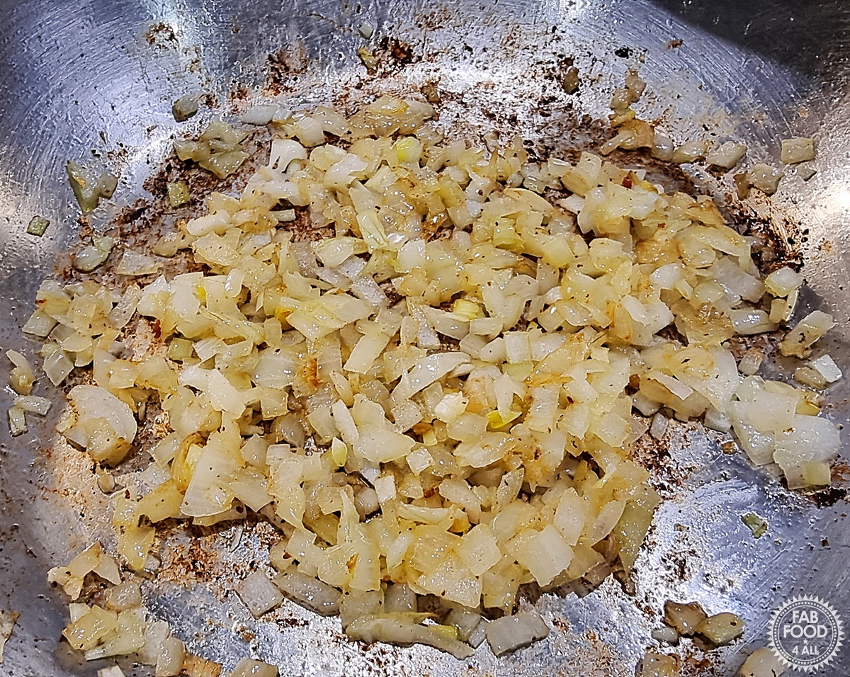 Diced onion and olive oil frying gently in a pan.