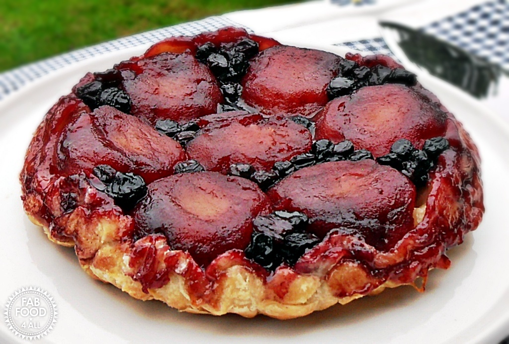 Apple & Blueberry Tarte Tatin on a white platter with pie server just visible.