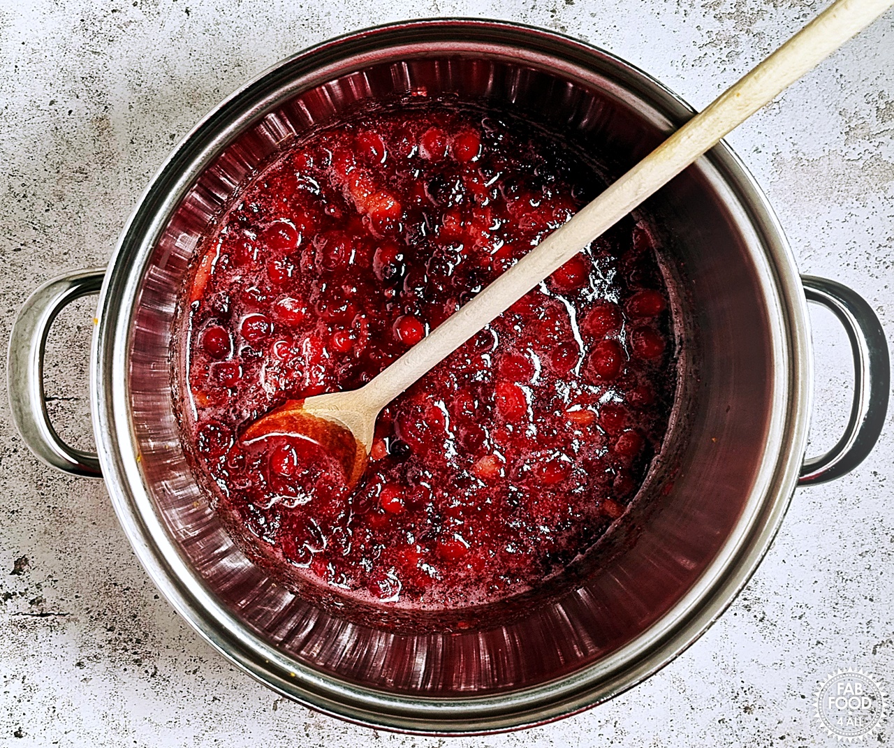 Pan shot showing that the granulated sugar has fully dissolved in the cooked cranberry and apple mixture.