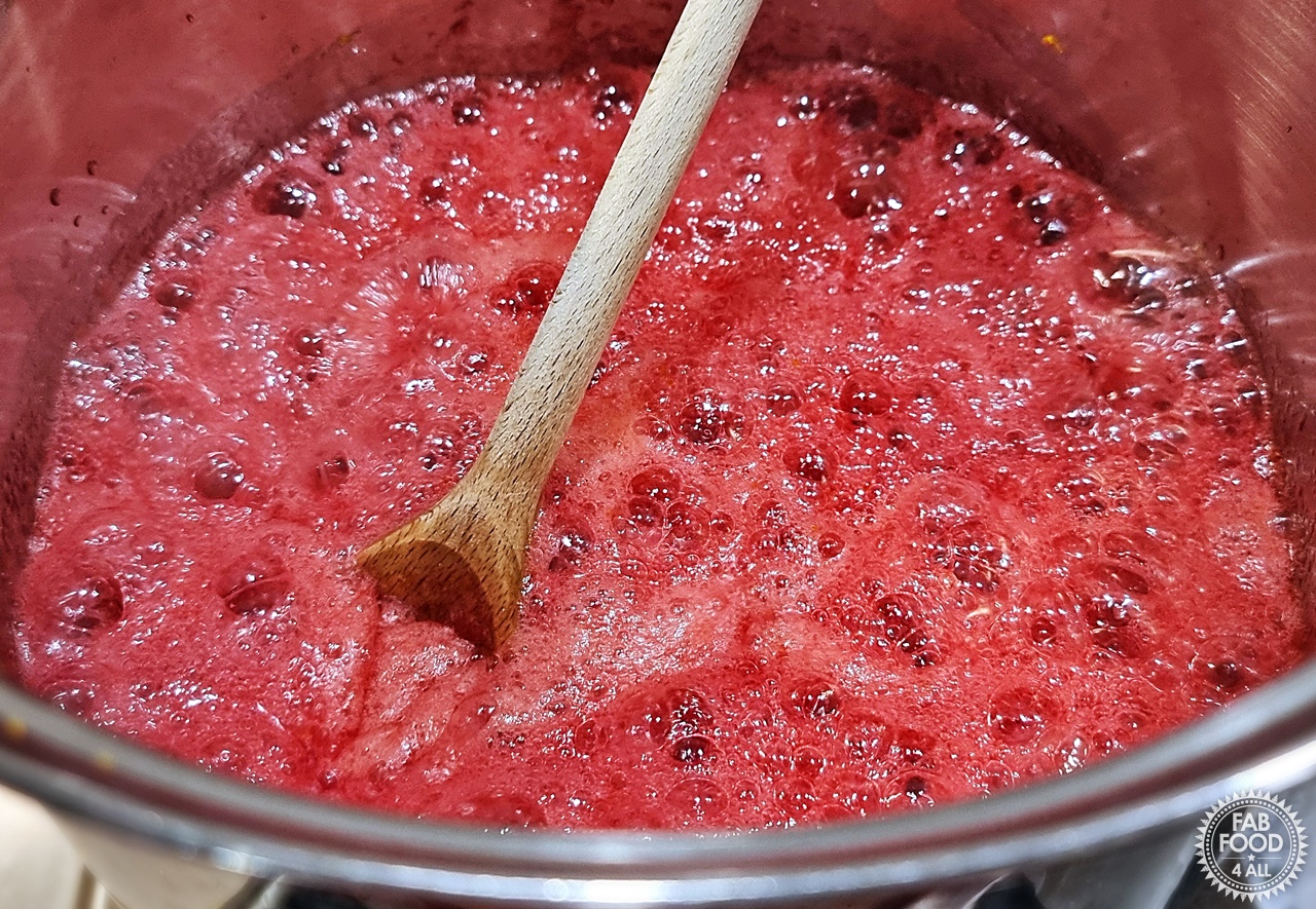 Easy Christmas Jam on a rolling boil in a deep stainless steel pot.